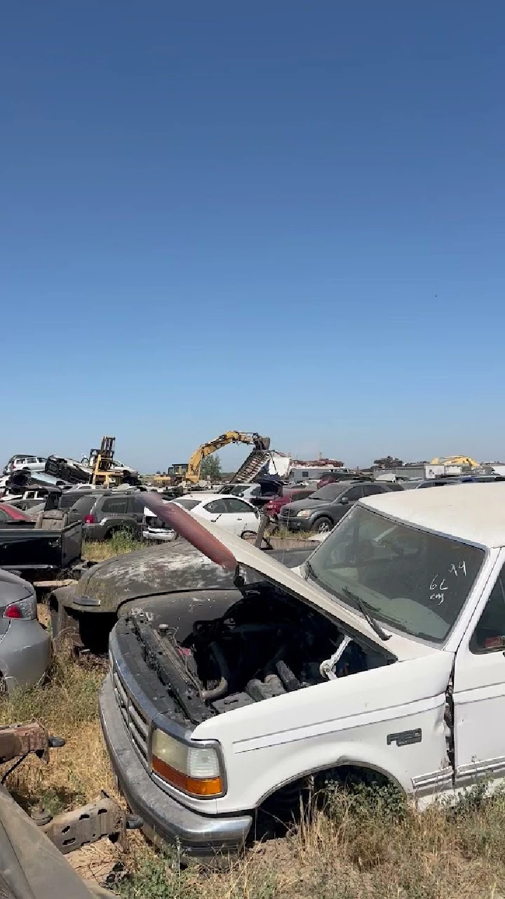 Junkyard scene with wrecked vehicles and machinery.