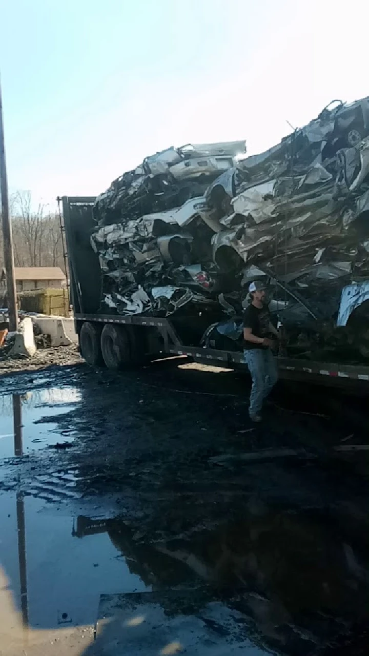 Loading crushed cars at a recycling facility.