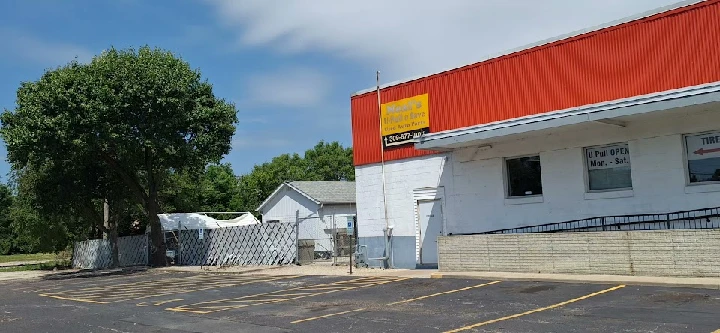 Neal Auto Parts store exterior with sign and trees.