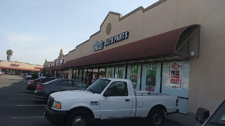 O'Reilly Auto Parts storefront with parked vehicles.