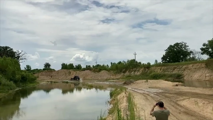 Outdoor scene with a vehicle near a water body.