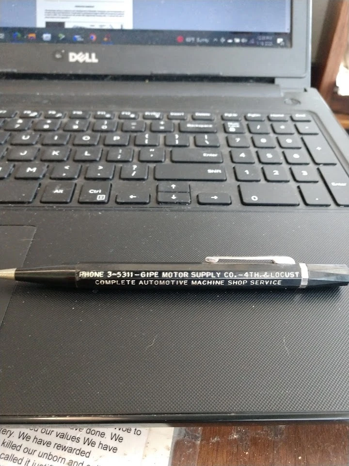 Pen on a laptop keyboard, featuring service details.