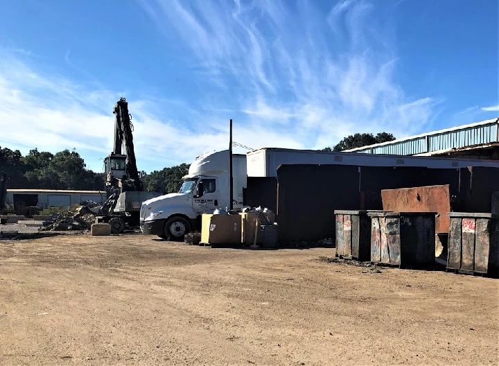 Recycling yard with truck and containers.