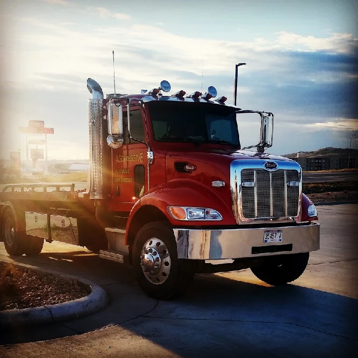 Red towing truck with Aggressive branding.