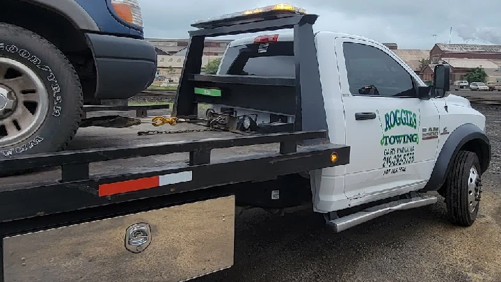 Roggie's towing truck with a vehicle on the bed.