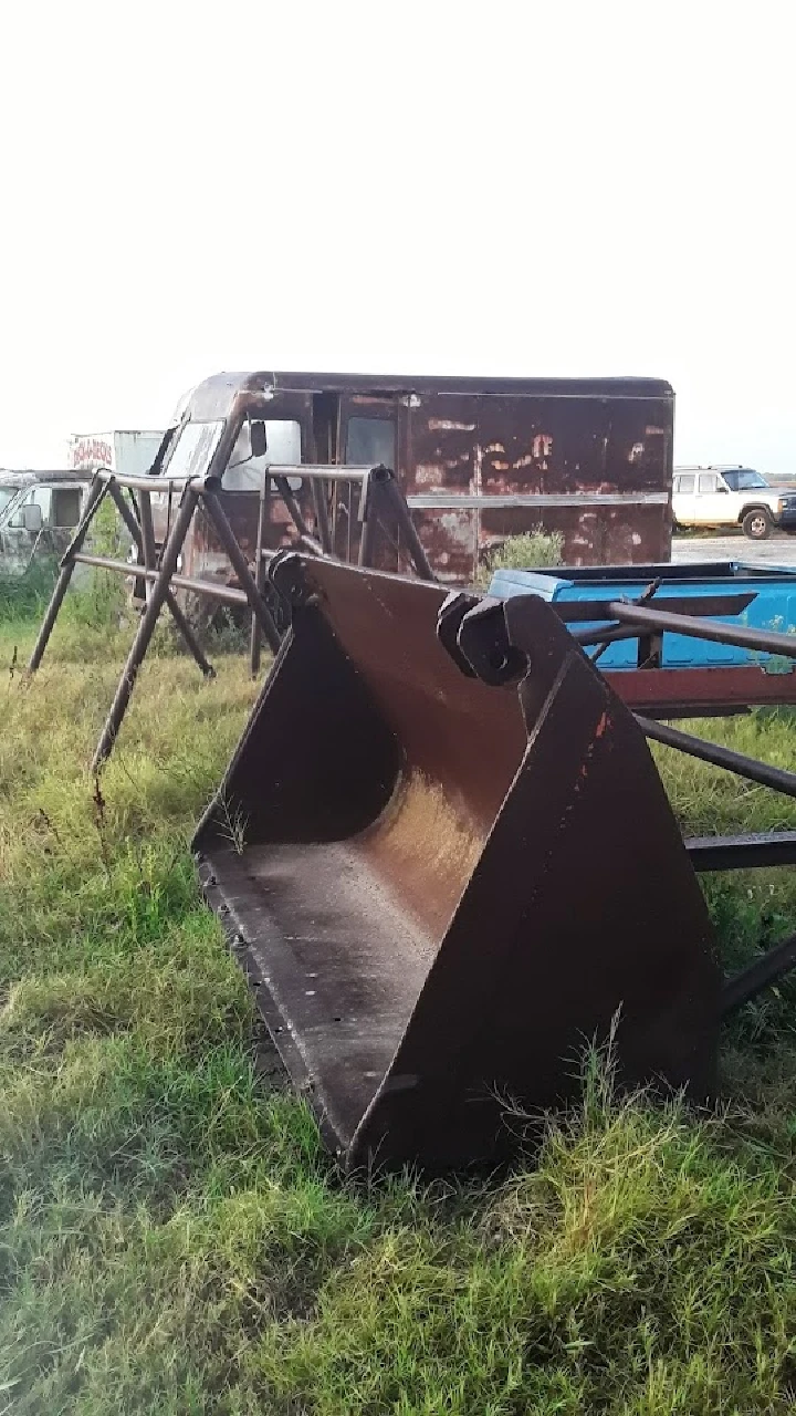 Rusty machinery and abandoned vehicles in a field.