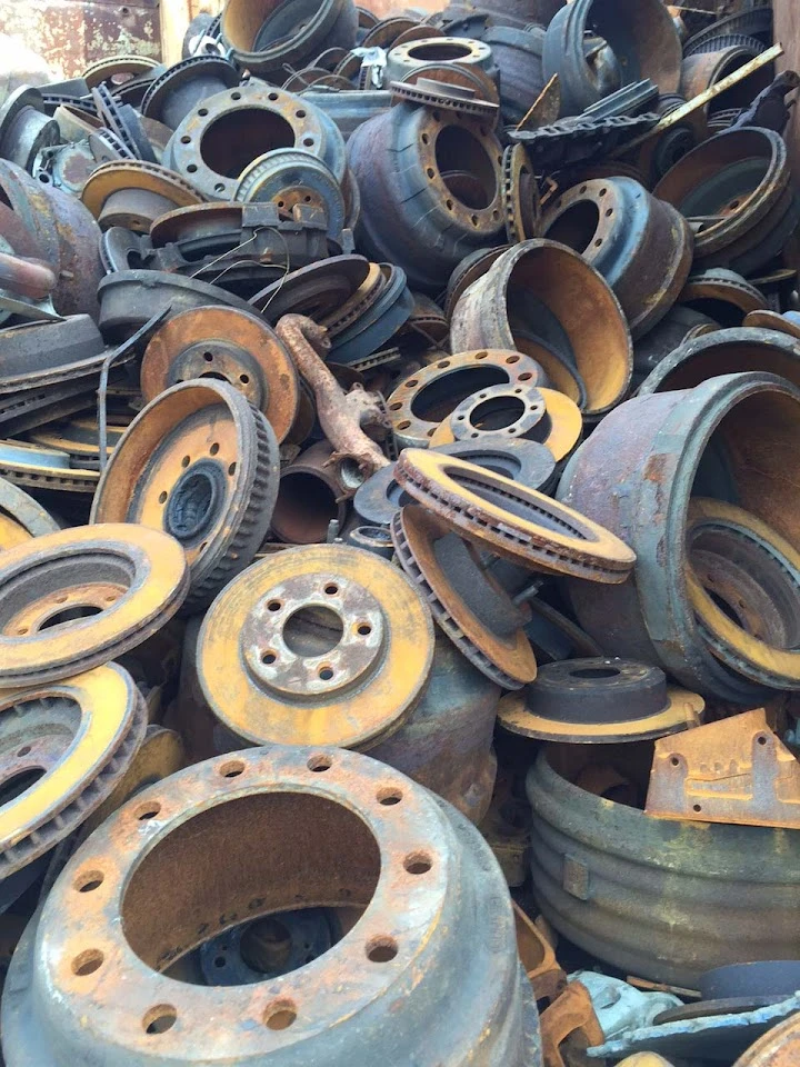 Rusty metal parts and machinery components stacked.