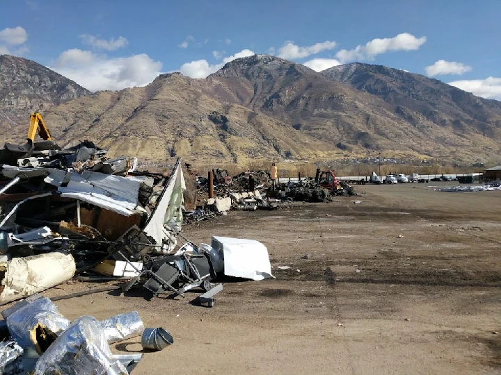 Scrap metal yard with mountains in the background.