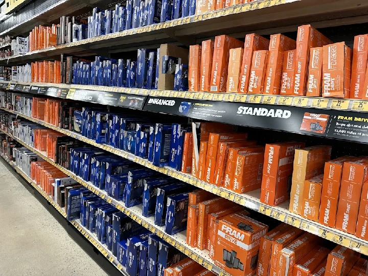 Shelves of auto parts with various product boxes.