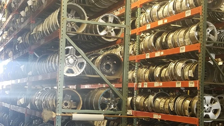 Shelves stocked with various auto parts and wheels.