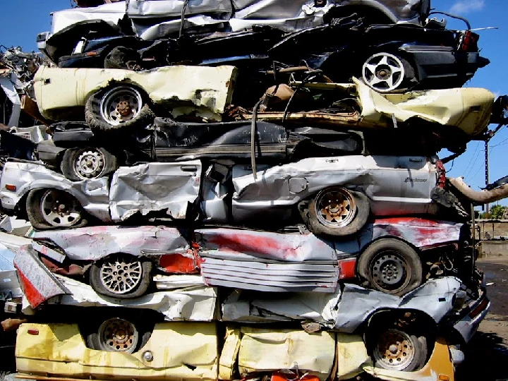 Stacked crushed cars at a recycling yard.