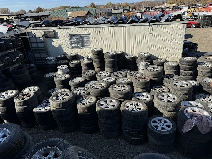 Stacked used tires at Meadow Auto Parts yard.