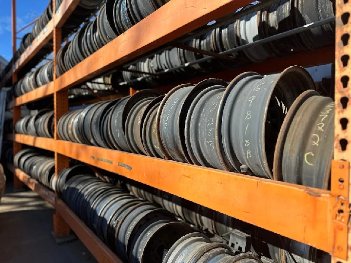 Storage shelves filled with car rims at Flint Auto Recycling.