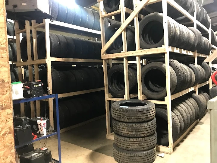 Tires organized on wooden shelves in a storage area.