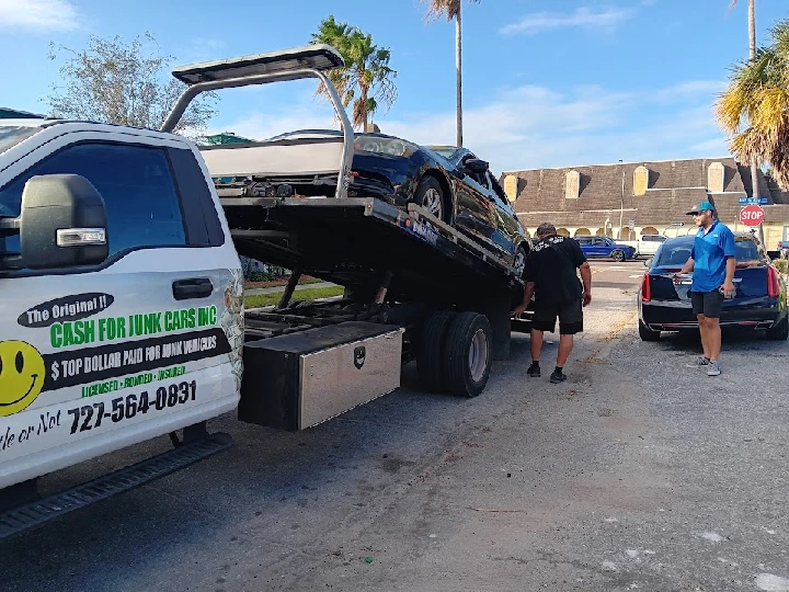 Tow truck loading a junk car for Cash for Junk Cars.