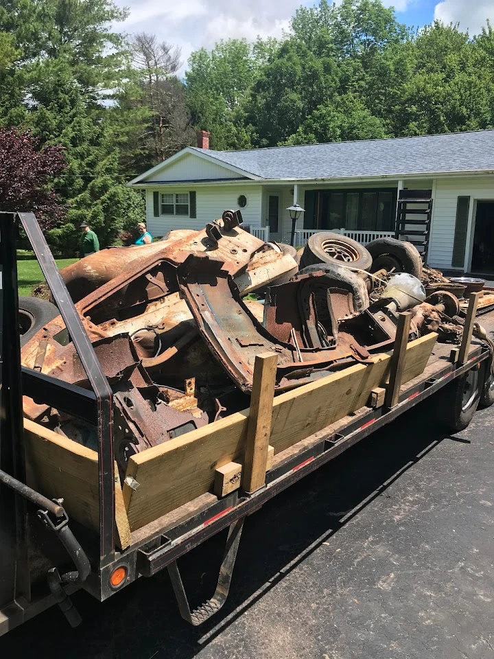 Trailer loaded with rusty car parts and scrap metal.