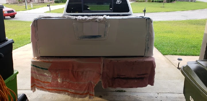 Truck bed being prepared for painting in garage.