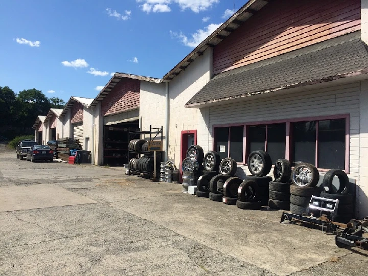 Used auto parts and tires outside a service garage.