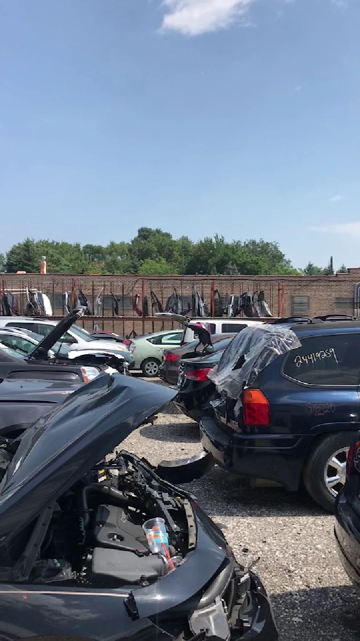 Used cars and auto parts in a junkyard.