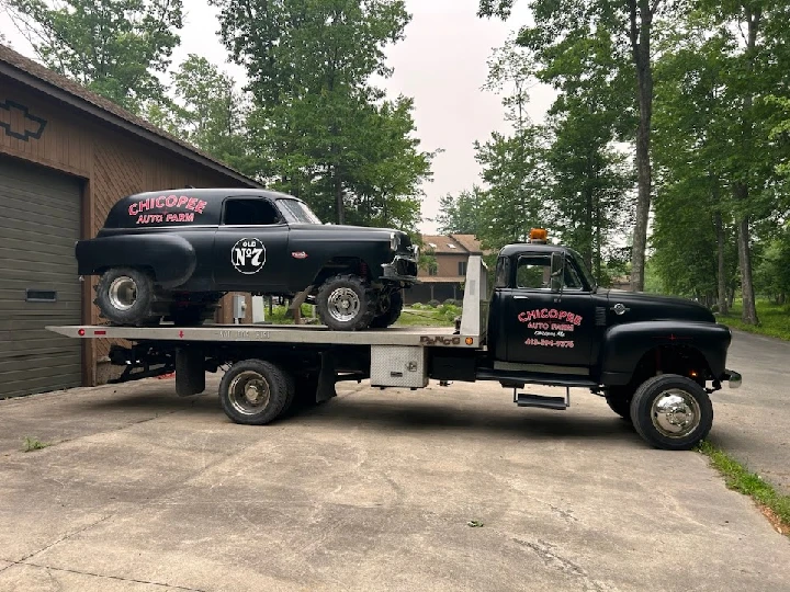 Vintage truck with car on tow at Chicopee Auto Farm.