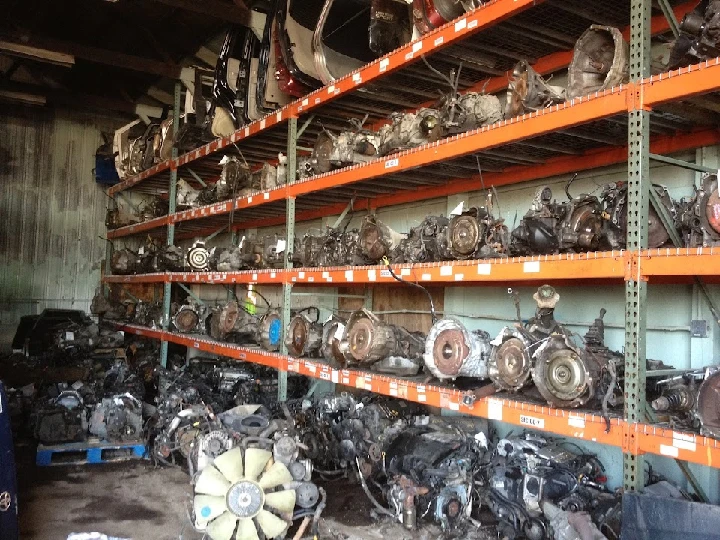 Warehouse filled with used car engines on shelves.