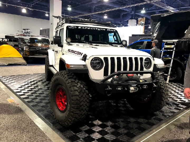 White Jeep Rubicon with custom modifications on display.