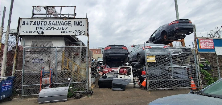 A&T Auto Salvage yard with stacked vehicles.