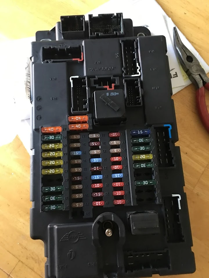 Auto parts fuse box with multiple fuses and connectors.