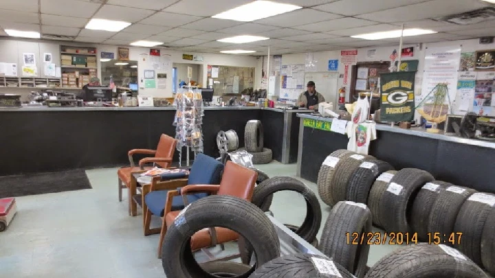 Auto parts shop interior with tires and seating area.