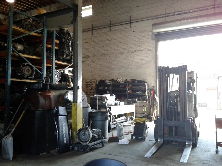 Auto parts warehouse interior with shelves and equipment.