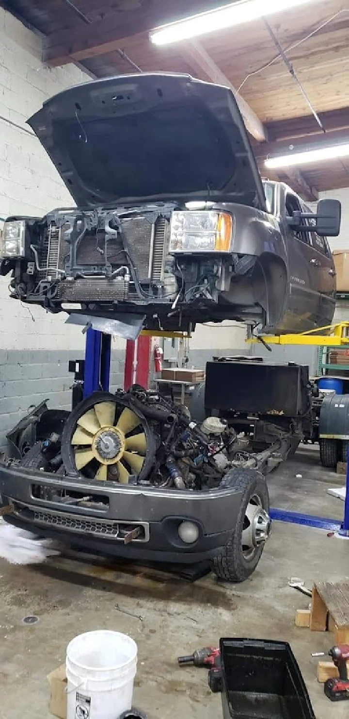 Auto parts workshop with lifted truck and engine.