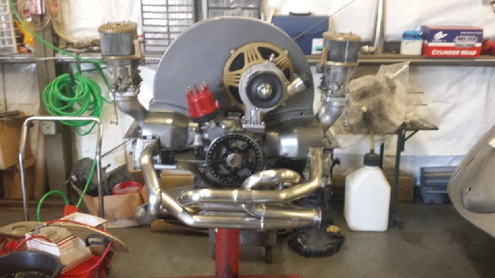 Automotive engine on a stand in a workshop.