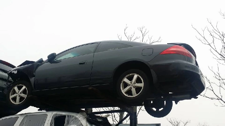 Black car on a storage rack at Mendez Auto Sales.