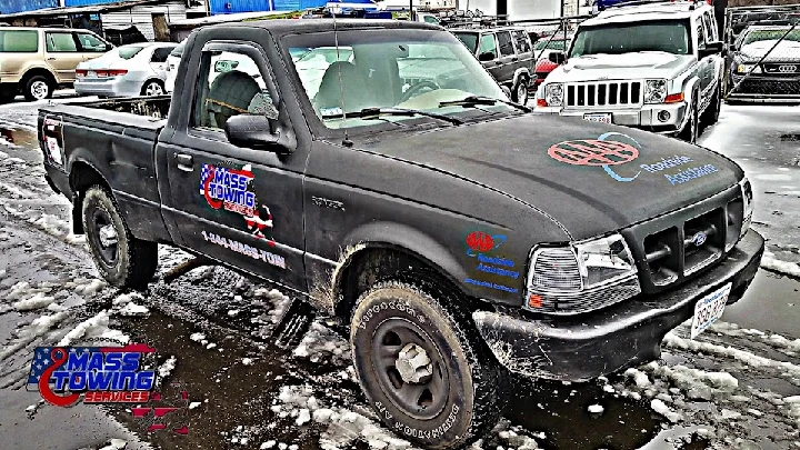 Black pickup truck with towing service branding.