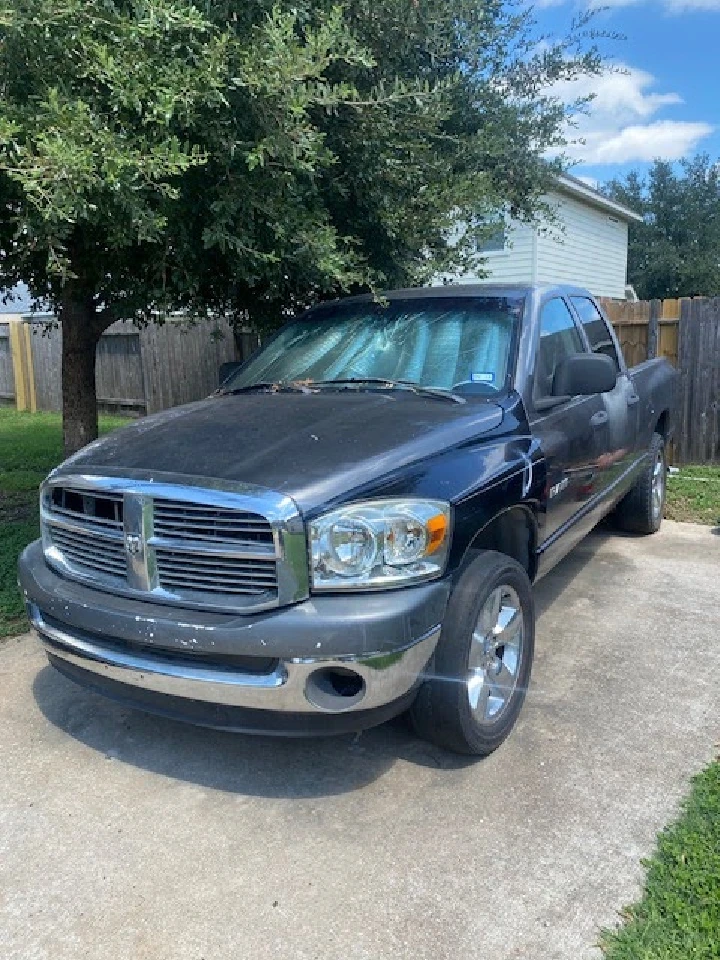 Black truck parked on concrete driveway.