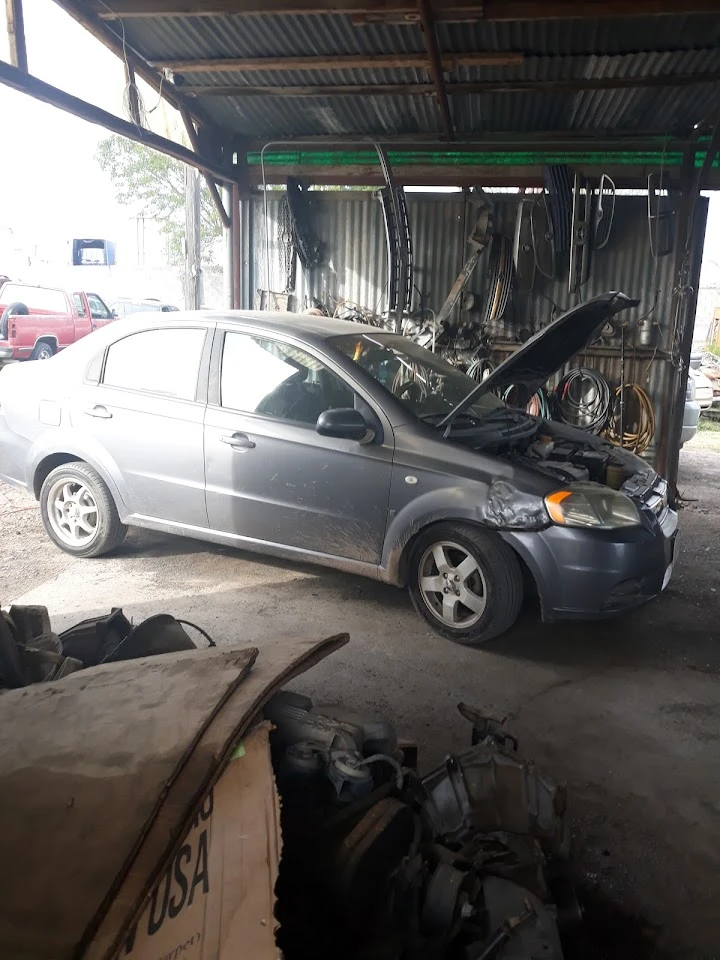 Car in garage with hood open for repairs.