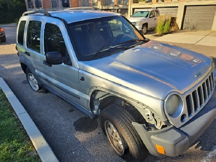 Damaged silver SUV parked on a residential street.