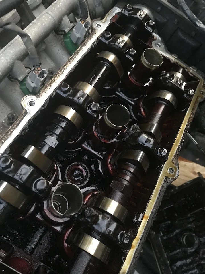 Engine components in a vehicle, showing oil buildup.