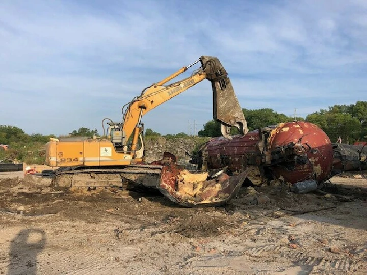 Excavator working on metal recycling site.