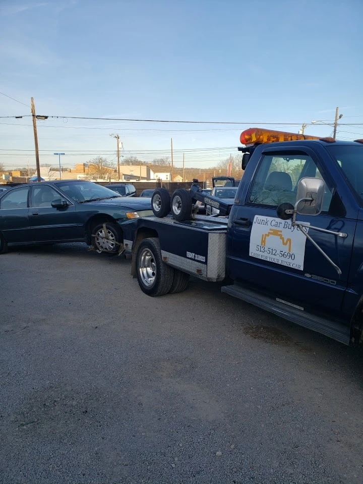 Junk Car Buyers LLC truck towing a vehicle.