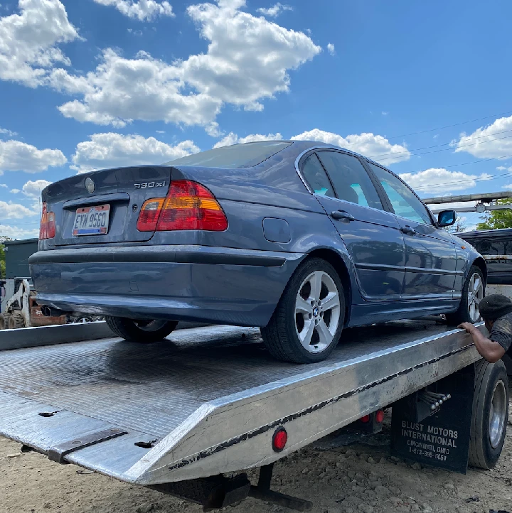 Junk car being loaded onto a tow truck.