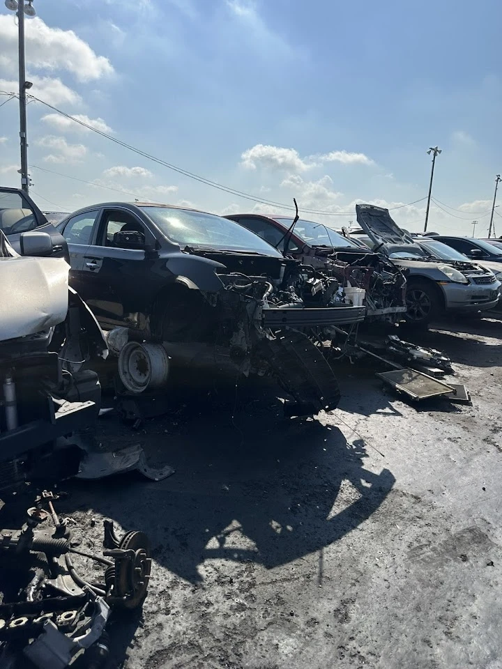 Junkyard scene with damaged cars and parts.