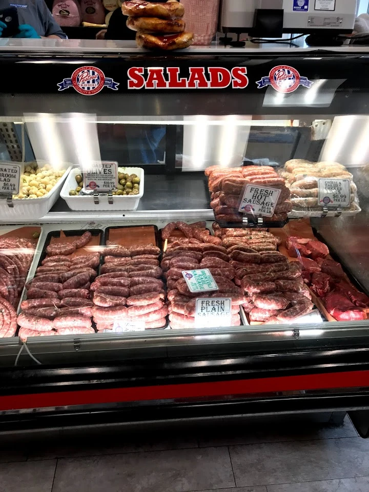 Meat display at a butchery with sausages and steaks.