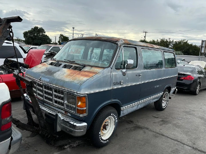 Old, rusty van in a junkyard for sale.