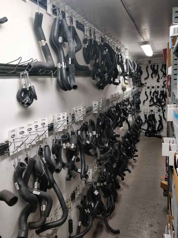 Rows of various automotive hoses displayed on hooks.