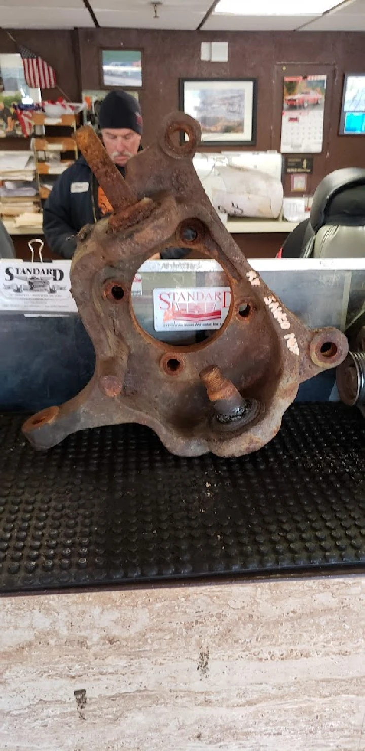 Rusty auto part on display at a wrecking company.