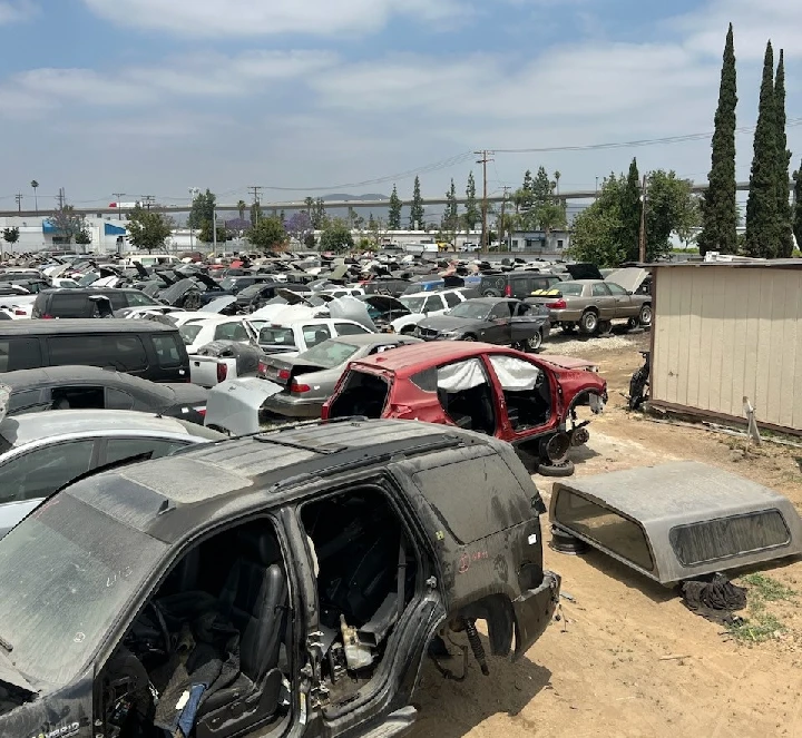 Salvage yard filled with wrecked cars and vehicles.