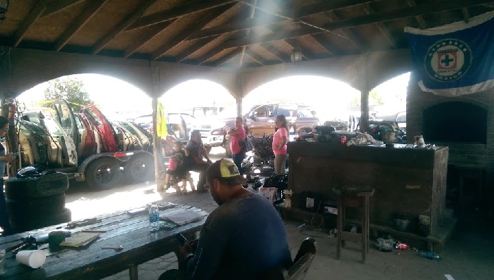 Scene of a repair shop with people and car parts.