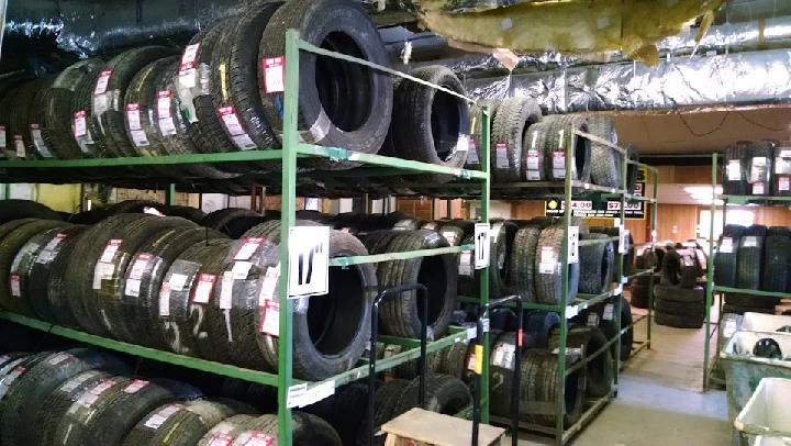 Shelves stacked with used tires in a shop.