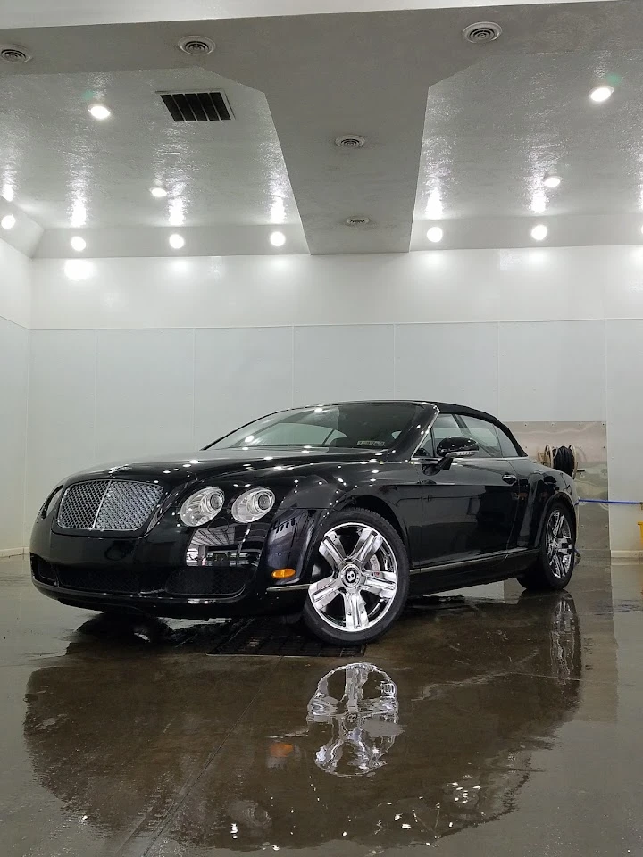 Shiny black convertible in a well-lit showroom.